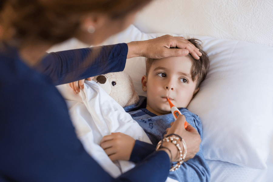 Mother takes son's temperature in the middle of the night.