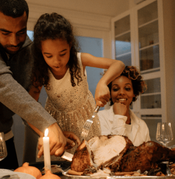 family cutting Thanksgiving turkey