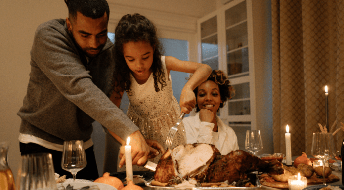 family cutting Thanksgiving turkey