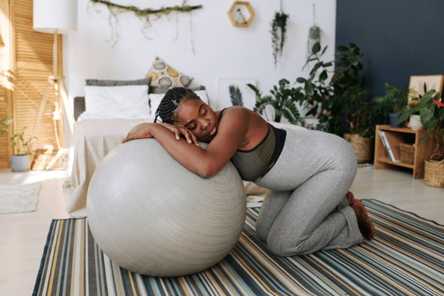 Pregnant mom in labor rests on a yoga ball at a birthing center