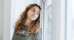 A teen looks out the window.