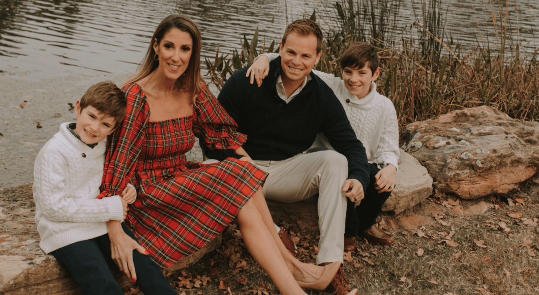 mother, sons, husband sitting on rocks near pond. 