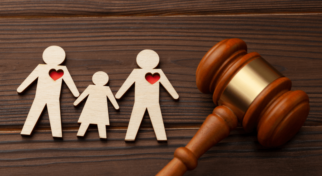 A wooden cutout of a family with red hearts, and a gavel.