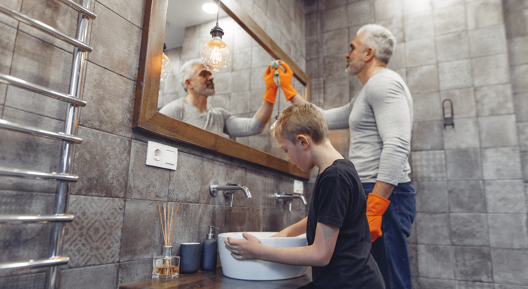 dad and son scrubbing bathroom together