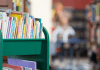 A return book cart is filled with children's books inside a library.