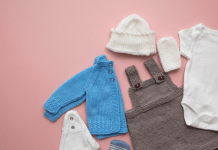 Baby overalls, a jacket, and accessories laid out