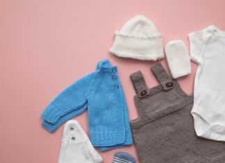 Baby overalls, a jacket, and accessories laid out