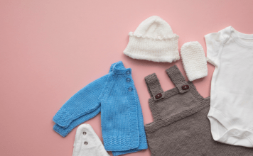 Baby overalls, a jacket, and accessories laid out