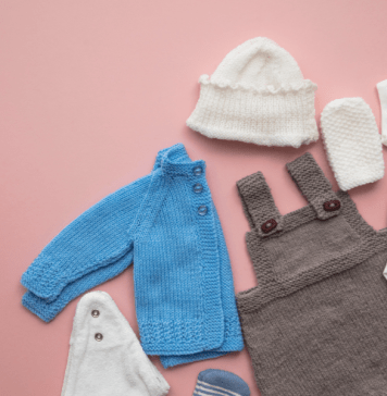 Baby overalls, a jacket, and accessories laid out