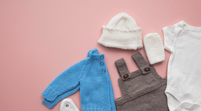 Baby overalls, a jacket, and accessories laid out