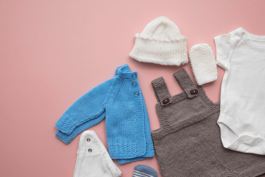 Baby overalls, a jacket, and accessories laid out