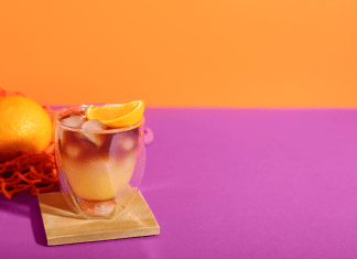 Orange cocktail drink on a pink and orange background.