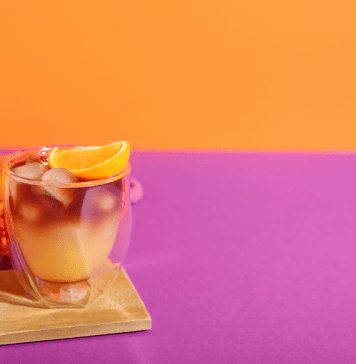 Orange cocktail drink on a pink and orange background.