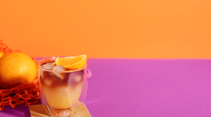 Orange cocktail drink on a pink and orange background.