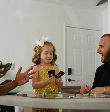 Biracial family with gay dads plays a card game for family game night