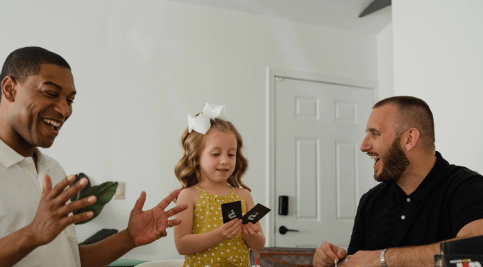 Biracial family with gay dads plays a card game for family game night