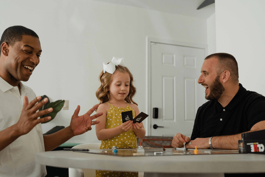 Biracial family with gay dads plays a card game for family game night