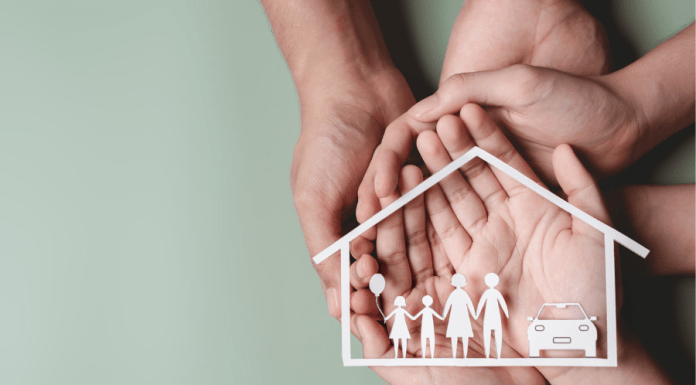 Hands hold the shape of a home and family and car.
